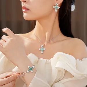Close-up of green and white zircon cross jewelry set worn by a model