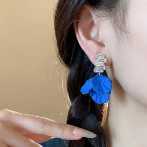 Elegantes pendientes de botón con pétalos de acrílico azul Klein y circonitas en modelo