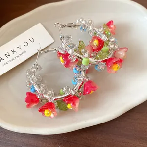 Detailed close-up of handmade floral bead hoop earrings with silver needles.
