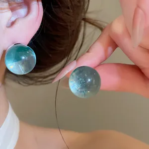 Detail view of translucent light blue resin ball earrings with sweet style