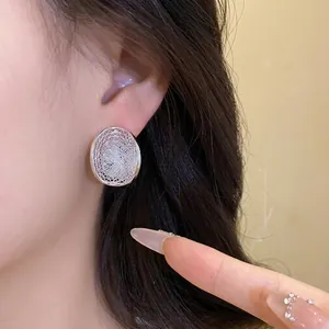 Elegant silver mesh hollow oval stud earrings with sparkly crystals for women, chic style.
