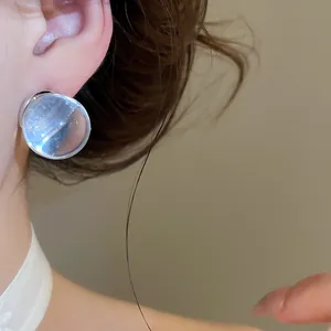 Detailed macro view of a transparent icy resin ball stud earring worn on ear