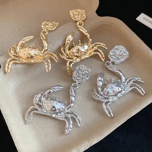 Fashionable gold and silver metal crab pendant earrings with a unique textured design