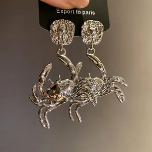 Silver-plated metal crab dangle earrings with detailed carving and high shine finish