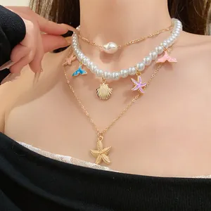 Dettaglio di una collana di perle a strati con ciondoli a forma di stella marina.