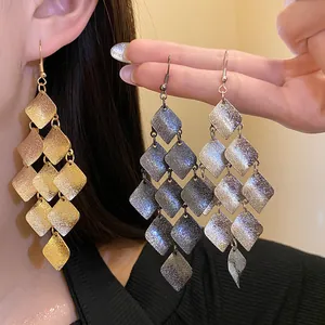 Detailed view of vintage matte metal rhombus tassel drop earrings in gold and silver