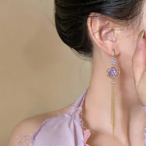 Elegant close-up of 18k gold plated tulip zircon tassel earrings worn on an Asian model