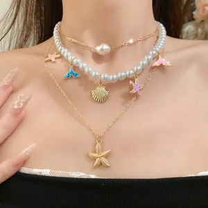 Dettaglio di collana multistrato tema oceano con perle e ciondoli a stella marina