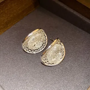 Detail view showing the delicate hollow silver mesh texture of these oval stud earrings