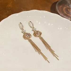 Detail view of 18k gold plated tulip earrings with zircon stones and long tassels