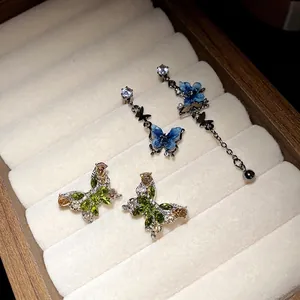 Élégantes boucles d'oreilles papillon en argent avec zircons et glands dans un écrin
