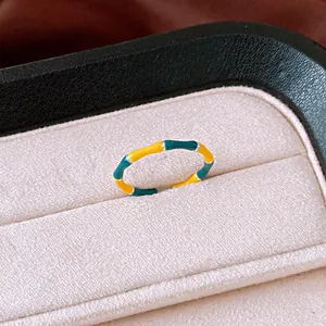 Dettaglio macro di un anello stile bambù con segmenti in smalto giallo e verde scuro