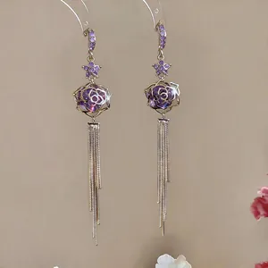 Close-up detail of elegant 18k gold plated purple zircon rose tassel earrings with silver needles