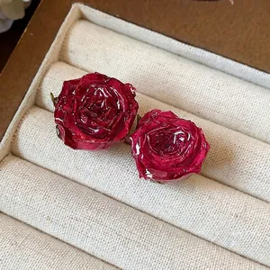 Exquisite handmade real rose flower resin earrings with silver needles on tray