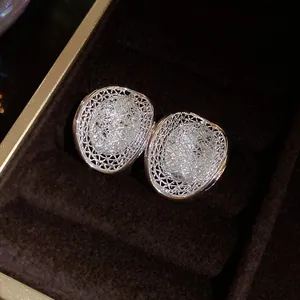 Detail of elegant silver mesh hollow oval stud earrings with sparkling rhinestones