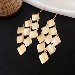 Detailed view of vintage matte gold tiered diamond-shaped tassel dangle earrings