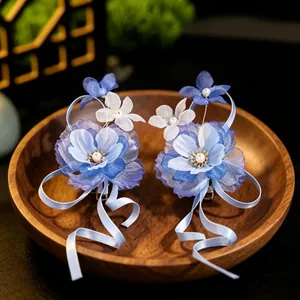 Detailed view of elegant blue chiffon flower hair clips with flowing ribbons and pearls.