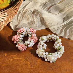 Elegant handmade floral pearl hair scrunchies in pink and white set on rustic wood