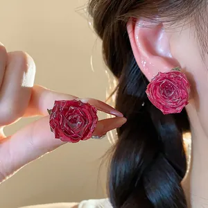 Detailed macro view of elegant handmade real rose stud earrings with silver needles