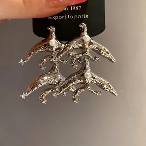 Vintage silver pearl drop earrings with abstract bird design and crystal accents
