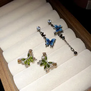 Détails exquis de boucles d'oreilles papillon en zircon dans un plateau à bijoux en velours.