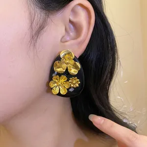 Elegant vintage black resin drop earrings with intricate gold flower embellishments