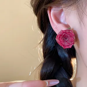 Detailed macro shot of a real red rose flower stud earring with silver needle