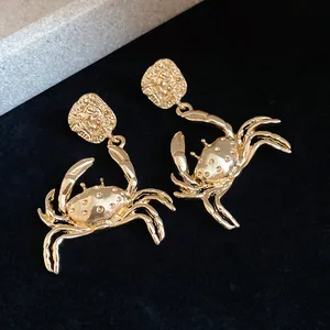 Detailed view of the intricate golden crab pendant earrings with textured finish
