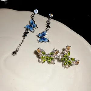 Vue macro détaillée de boucles d'oreilles et clous papillon élégants en zircon avec tige argent