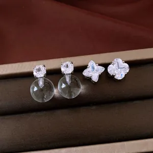 Elegant detail of silver needle zircon clover and crystal sphere stud earrings