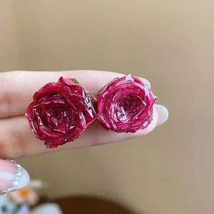 Detailed macro view of resin-coated real rose stud earrings showing intricate petal texture