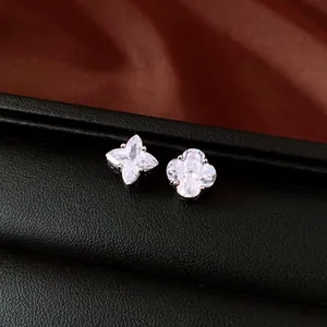 Macro detail showing the sparkling zircon facets of asymmetric star and clover stud earrings