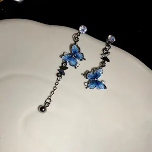 Détail de boucles d'oreilles papillon en résine bleue avec accents de zircon