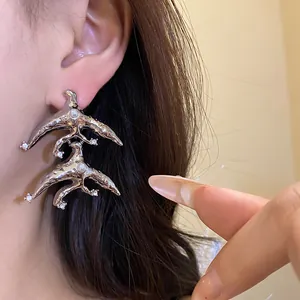 Close-up of stylish silver molten geometric earrings with inlaid pearls and crystals