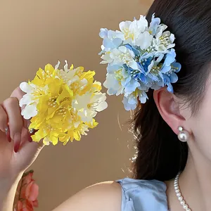 Detailed view of elegant fabric flower hair clips in yellow and blue, perfect for vacation