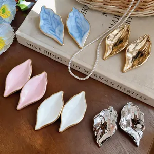 Collection of vintage metallic leaf-shaped earrings featuring diverse textures and colors