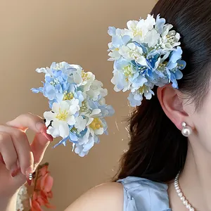 Close-up of elegant blue and white cloth flower hair clips worn by a model