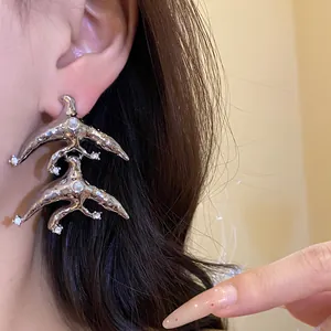 Detail view of vintage geometric silver earrings with rhinestones and pearls on model.