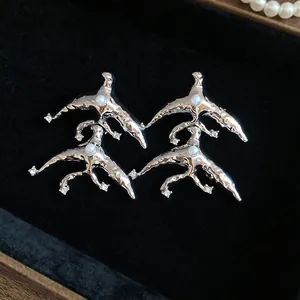 Detailed close-up of abstract organic silver earrings featuring white pearls and tiny crystals