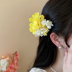 Elegant yellow and white fabric flower hair clip for a sweet and airy resort look