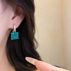 Primo piano di orecchini pendenti con zircone turchese indossati da una modella