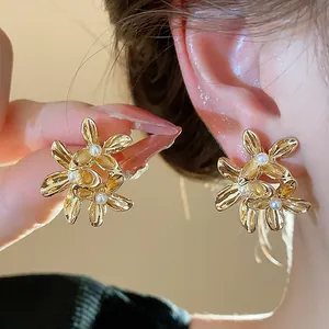 Exquisite detail of vintage French floral earrings with pearls shown worn on ear.