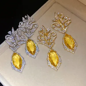 Nahaufnahme eleganter Blumen-Ohrhänger mit gelben Zirkonia-Steinen im Markise-Schliff