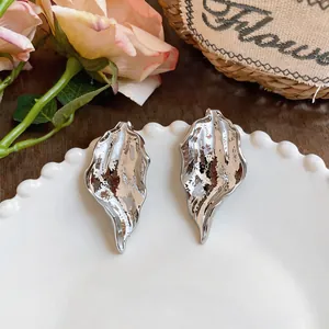 Detailed close-up of these silver-tone abstract leaf earrings with textured metallic surface