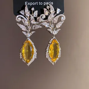 Detailansicht der 18 Karat vergoldeten Ohrringe mit Zirkonia-Blume und gelbem Stein