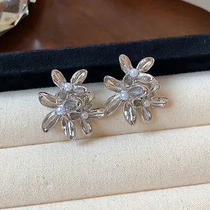 Detailed close-up of vintage silver flower stud earrings with elegant pearl accents