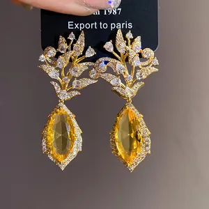 Detailansicht vergoldeter Blumenohrringe mit gelben Marquise-Edelsteinen und CZ-Akzenten.