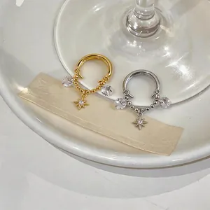 Detail showing gold and silver star pendant ear clips with sparkling zircons.