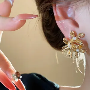 Detailed macro shot of vintage gold flower stud earrings with elegant pearl centers