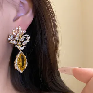 Nahaufnahme von eleganten 18k vergoldeten Blumenohrringen mit gelbem Edelstein